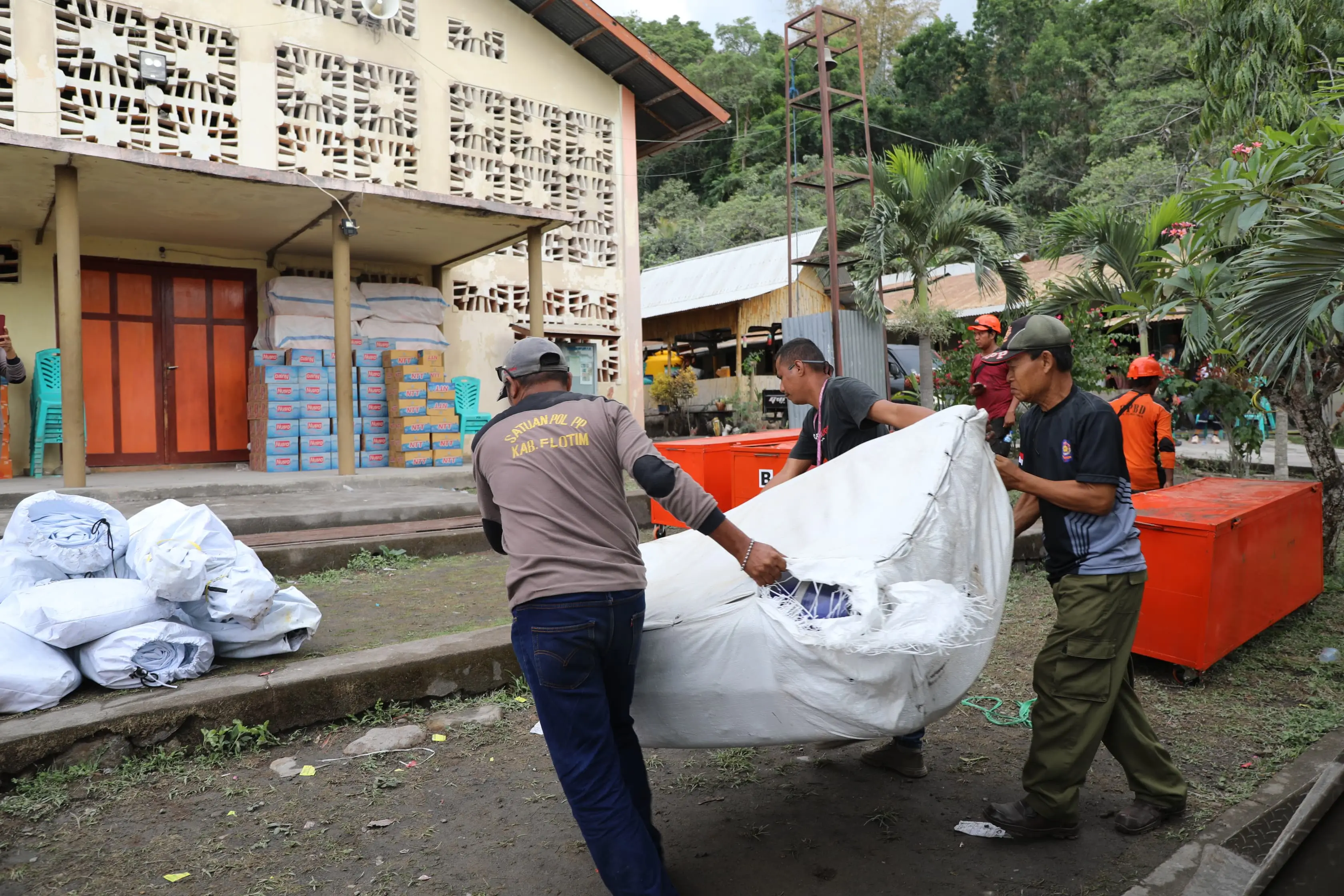 Tim Gabungan saat menurunkan bantuan dari BNPB untuk warga di pos pengungsian Desa Kringa, Kabupaten Sikka, Nusa Tenggara Timur pada Kamis (7/11).